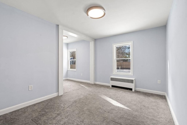 carpeted empty room featuring radiator