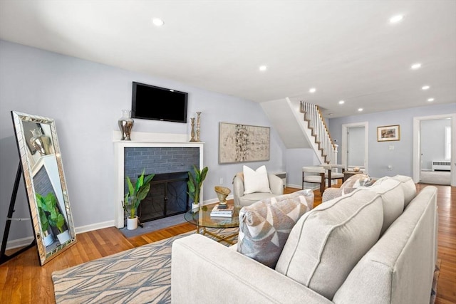 living room featuring light hardwood / wood-style floors, radiator heating unit, and a fireplace