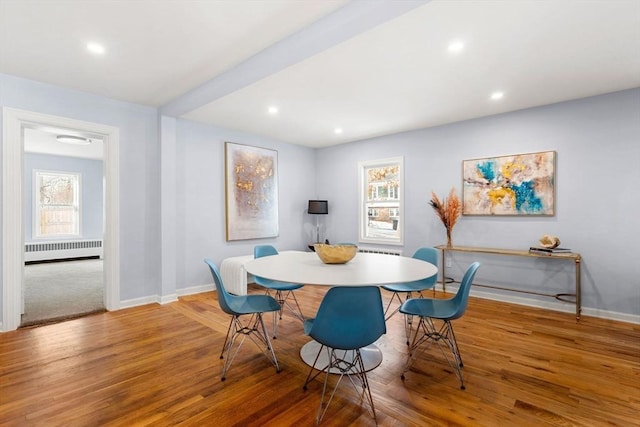 dining area with hardwood / wood-style flooring and radiator