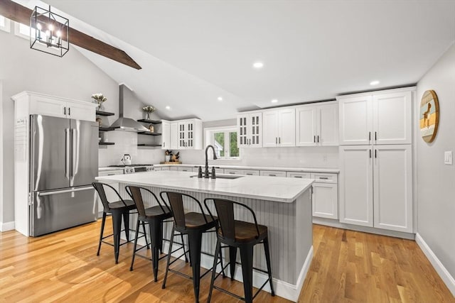 85 Mann Hill Rd, Scituate, MA 02066 - kitchen with freestanding refrigerator, range hood, backsplash, a center island with sink, and white cabinetry