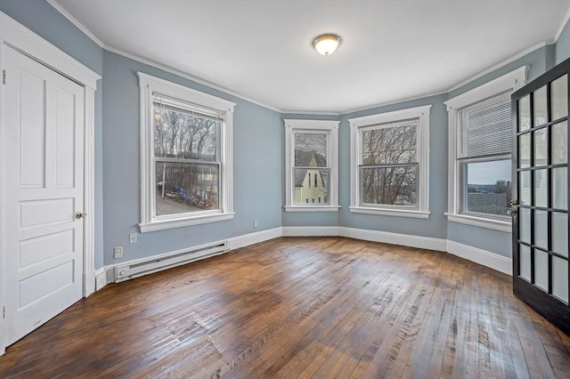 empty room with baseboard heating, hardwood / wood-style flooring, ornamental molding, and baseboards