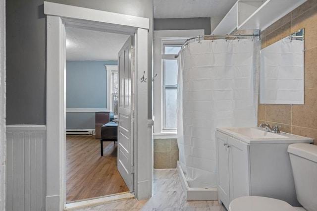 bathroom featuring baseboard heating, a stall shower, toilet, and vanity