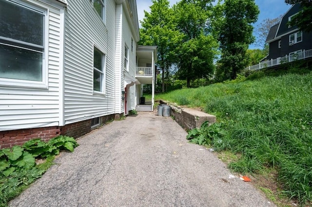 view of home's exterior with a balcony and driveway