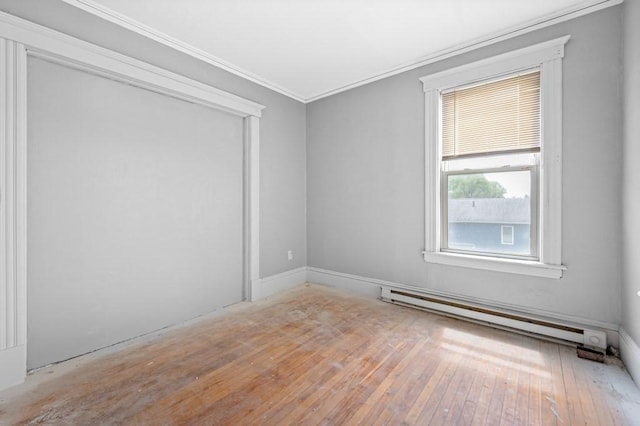 empty room with baseboard heating, ornamental molding, and wood-type flooring