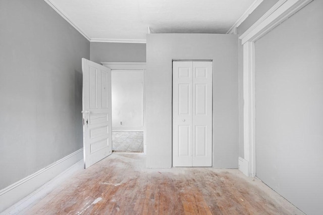 unfurnished bedroom with crown molding, wood finished floors, and a closet