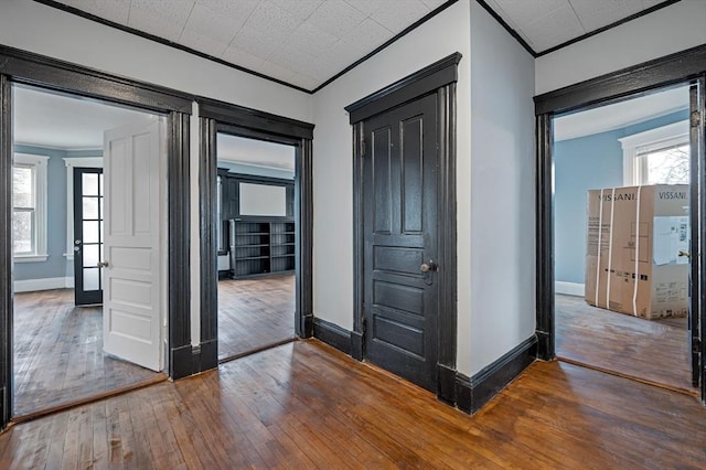 unfurnished room featuring ornamental molding, hardwood / wood-style floors, and baseboards