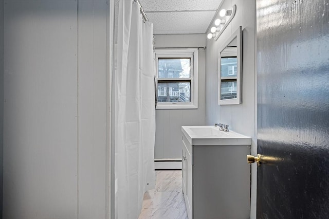 bathroom with a baseboard radiator, marble finish floors, and vanity