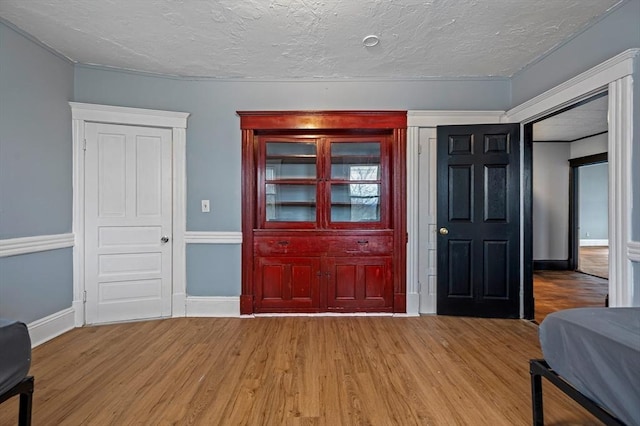 entryway with wood finished floors, a textured ceiling, and baseboards