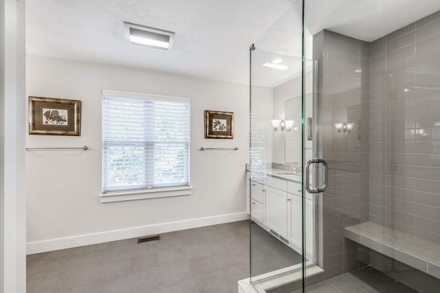 full bath featuring a shower stall, visible vents, baseboards, and vanity