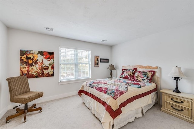 bedroom with baseboards, visible vents, and light colored carpet