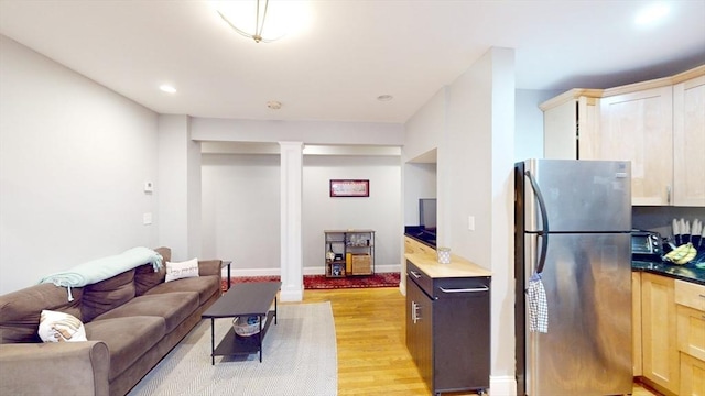 living area featuring recessed lighting, light wood-style floors, baseboards, and ornate columns