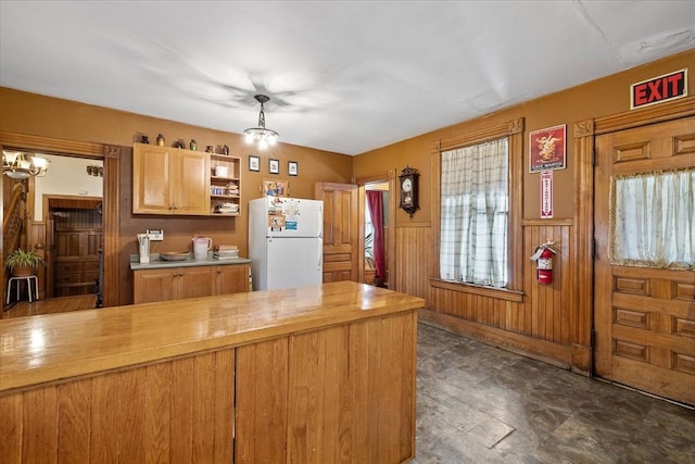 kitchen with butcher block countertops, freestanding refrigerator, open shelves, and an inviting chandelier