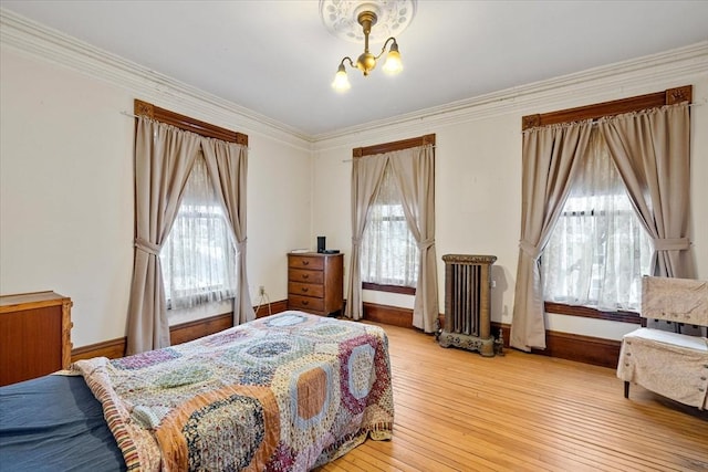 bedroom featuring a chandelier, multiple windows, light wood-type flooring, and crown molding