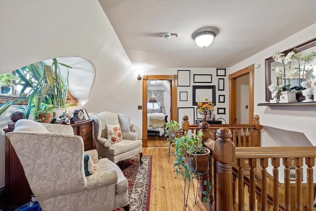 living area featuring wood-type flooring and an upstairs landing