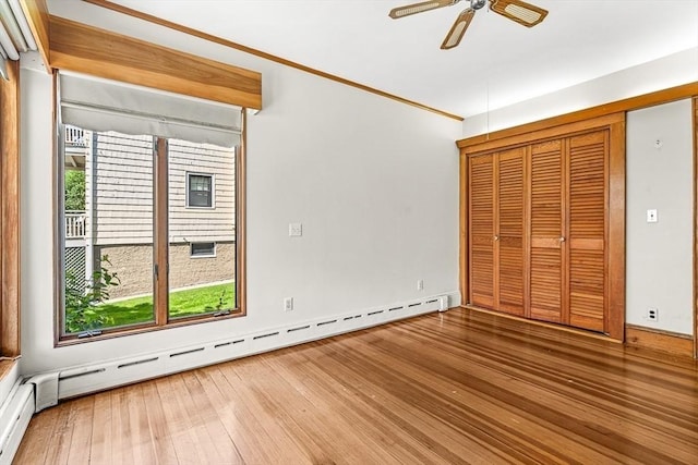 68 Barnard Ave, Watertown, MA 02472 - unfurnished bedroom with baseboard heating, hardwood / wood-style floors, a ceiling fan, and a closet
