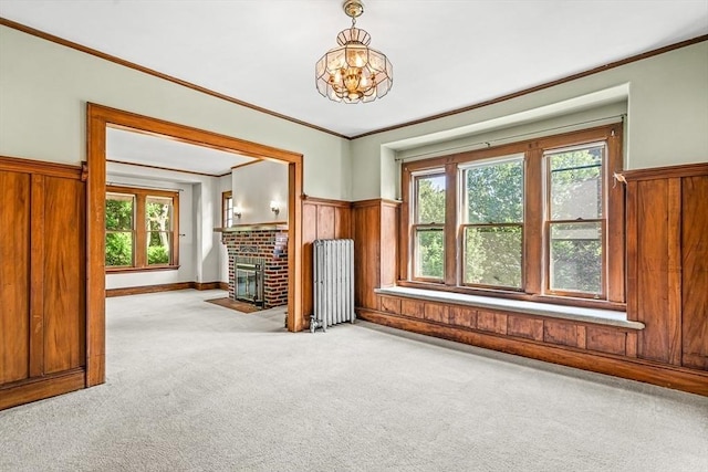 68 Barnard Ave, Watertown, MA 02472 - unfurnished living room featuring light colored carpet, wooden walls, radiator heating unit, a brick fireplace, and ornamental molding