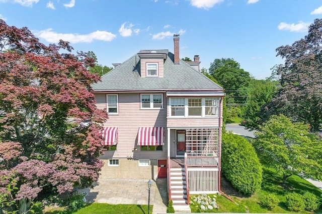68 Barnard Ave, Watertown, MA 02472 - back of property featuring a chimney, a shingled roof, and stairs