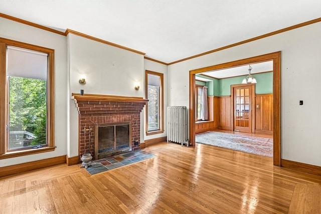 68 Barnard Ave, Watertown, MA 02472 - unfurnished living room with radiator, wood finished floors, wainscoting, a fireplace, and crown molding
