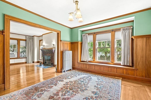 68 Barnard Ave, Watertown, MA 02472 - unfurnished living room featuring plenty of natural light, a chandelier, wood finished floors, ornamental molding, and a fireplace