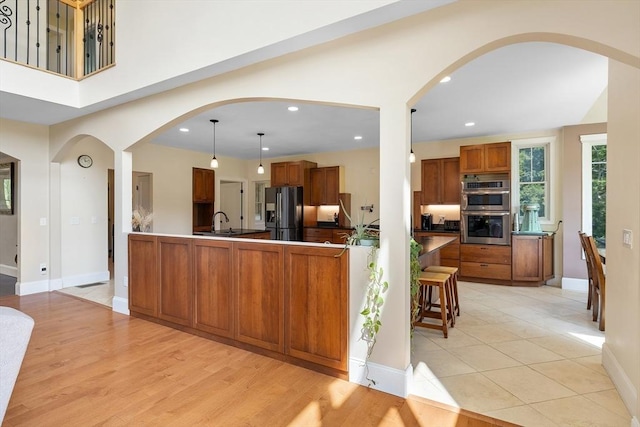 19 Hardscrabble Rd, Sterling, MA 01564 - kitchen with fridge with ice dispenser, stainless steel double oven, brown cabinetry, recessed lighting, and arched walkways