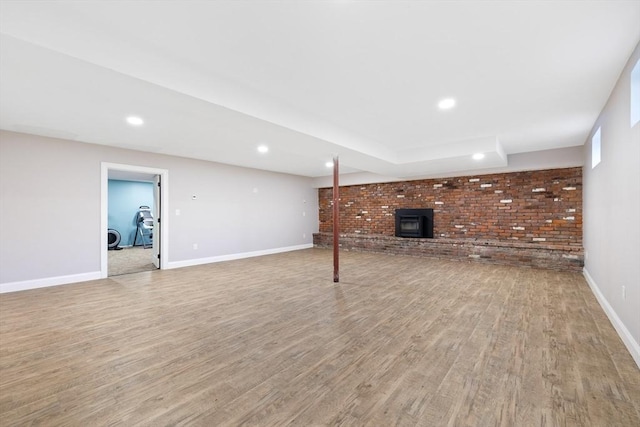 19 Hardscrabble Rd, Sterling, MA 01564 - unfurnished living room with brick wall, light wood-style flooring, recessed lighting, and a wood stove