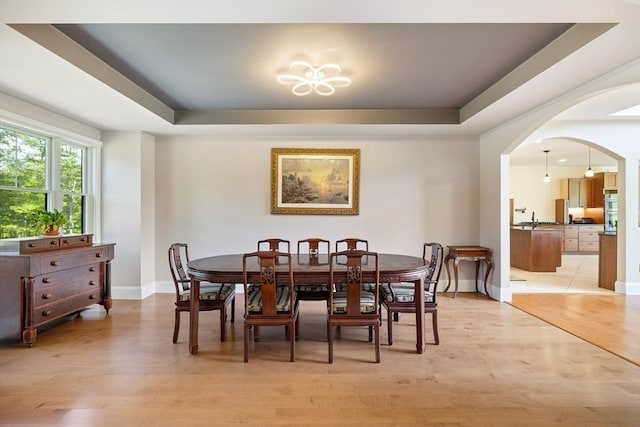 19 Hardscrabble Rd, Sterling, MA 01564 - dining room featuring a tray ceiling, light wood-style flooring, a chandelier, and arched walkways