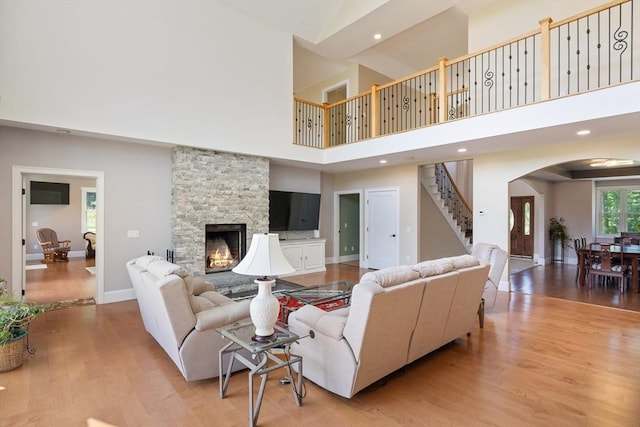 19 Hardscrabble Rd, Sterling, MA 01564 - living area with a high ceiling, stairs, arched walkways, light wood-style flooring, and a stone fireplace