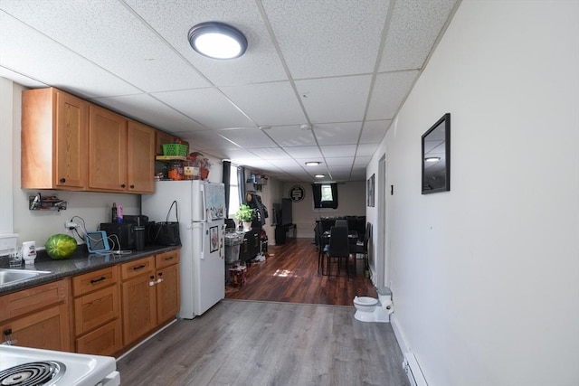 79-81 N Main St, Webster, MA 01570 - kitchen with white appliances, wood finished floors, a drop ceiling, dark countertops, and brown cabinetry