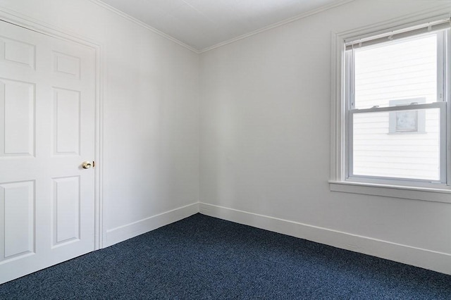 unfurnished room with baseboards, dark carpet, and crown molding