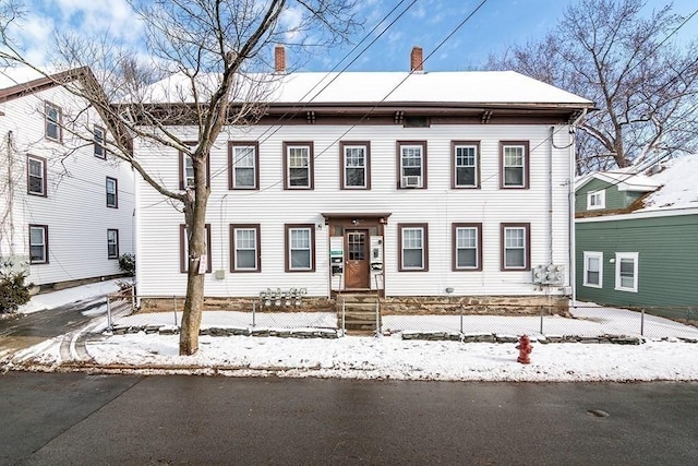 view of front facade featuring a fenced front yard and a chimney