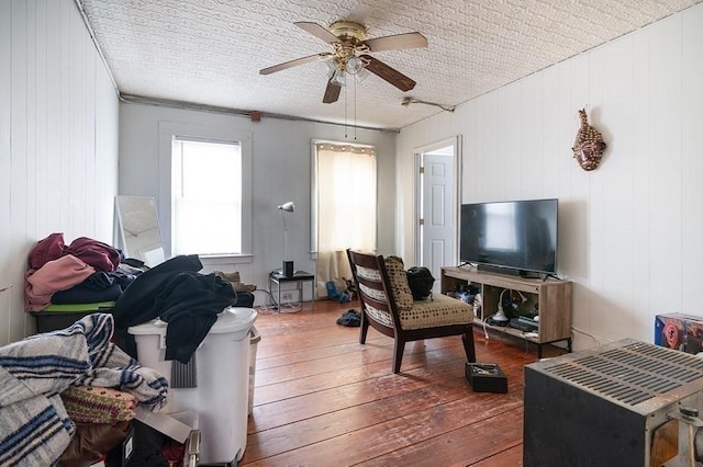 living area with a ceiling fan and hardwood / wood-style flooring