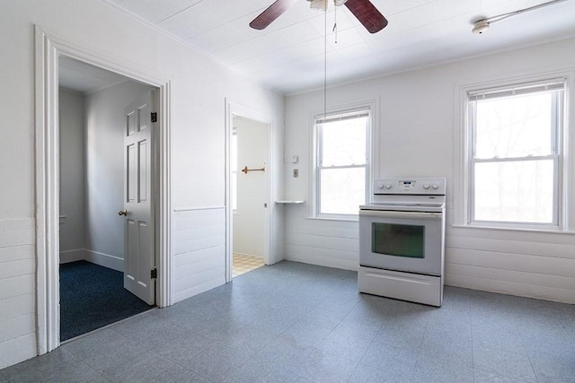 kitchen featuring tile patterned floors, a wainscoted wall, a ceiling fan, and white electric range oven