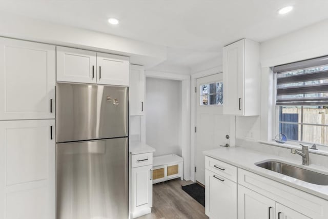 kitchen featuring stainless steel refrigerator, white cabinetry, dark hardwood / wood-style flooring, and sink