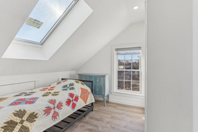 bedroom with light hardwood / wood-style flooring and lofted ceiling with skylight