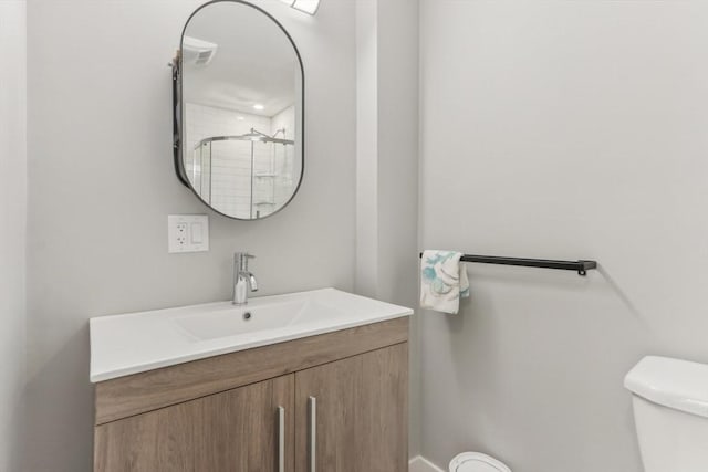 bathroom with vanity, an enclosed shower, and toilet