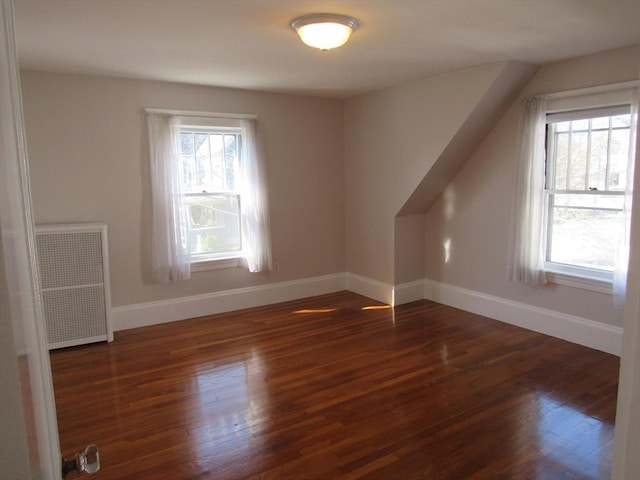 additional living space with radiator, baseboards, and wood finished floors