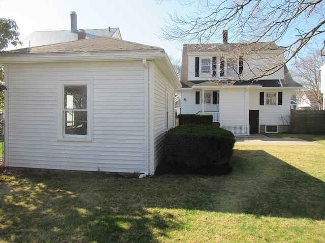 rear view of property with fence, a chimney, and a yard