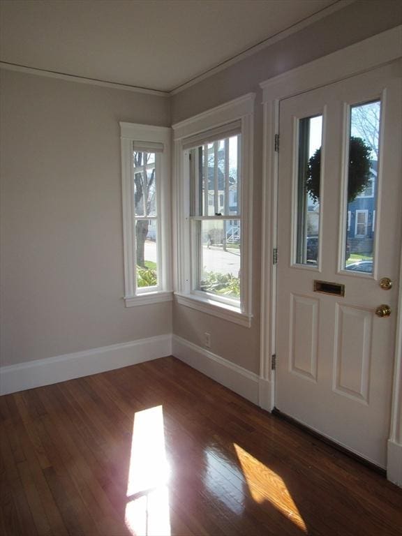 doorway to outside featuring baseboards and wood finished floors