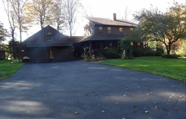 view of front of home featuring driveway, a garage, and a front lawn