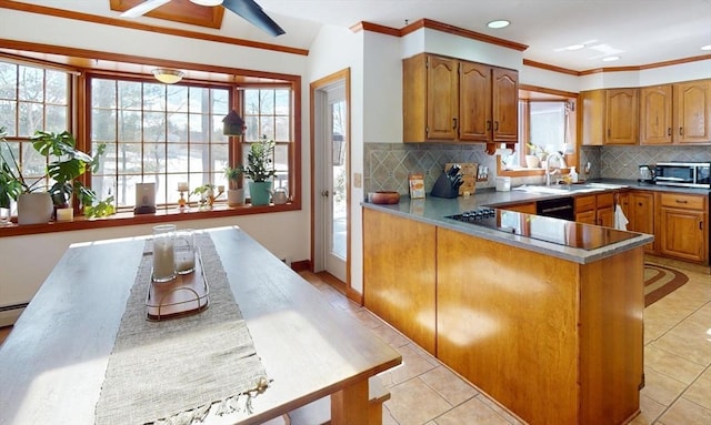 kitchen featuring plenty of natural light, stainless steel microwave, and brown cabinetry