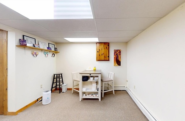 interior space with a paneled ceiling, baseboards, baseboard heating, and carpet flooring