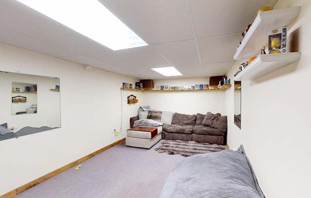 living area with carpet floors, a drop ceiling, and baseboards