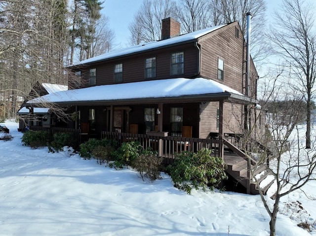 view of front facade featuring covered porch and a chimney