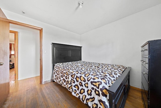 bedroom with dark hardwood / wood-style flooring