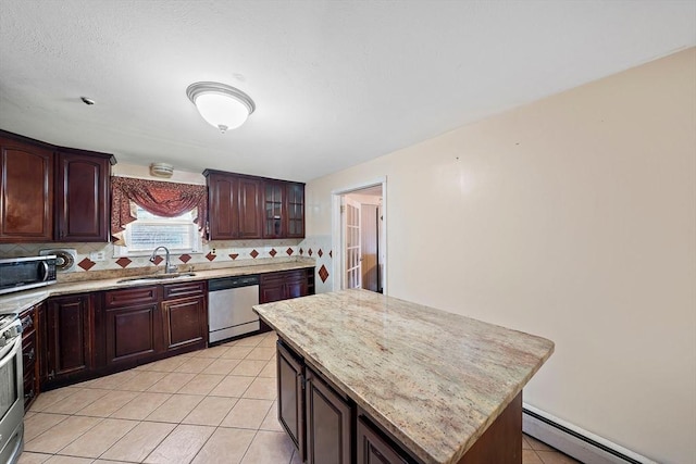 kitchen featuring tasteful backsplash, sink, a center island, a baseboard heating unit, and stainless steel appliances