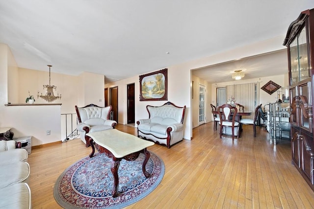 living room with an inviting chandelier and light wood-type flooring