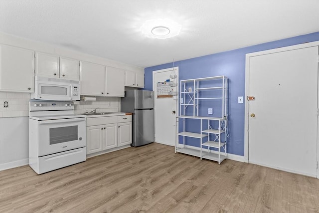 kitchen with sink, white cabinetry, light wood-type flooring, white appliances, and backsplash