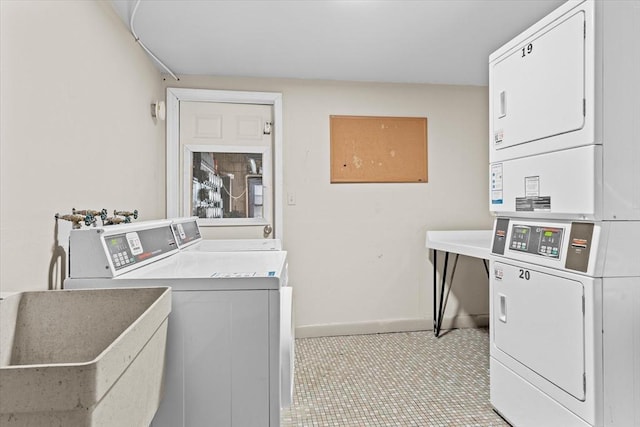 clothes washing area with washer and dryer, stacked washer and clothes dryer, and sink