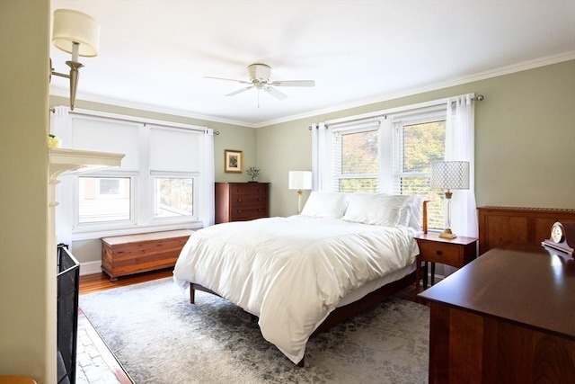 bedroom with ceiling fan, wood finished floors, and crown molding