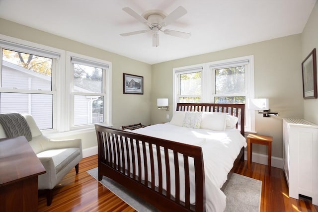 bedroom featuring a ceiling fan, baseboards, and wood finished floors